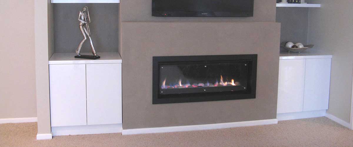 A Heatilator fireplace installed in a wall-mounted setup with a television positioned above for a modern home design