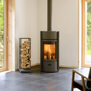 A Stuv 30 wood fireplace positioned in a room alongside a chair, creating a warm atmosphere