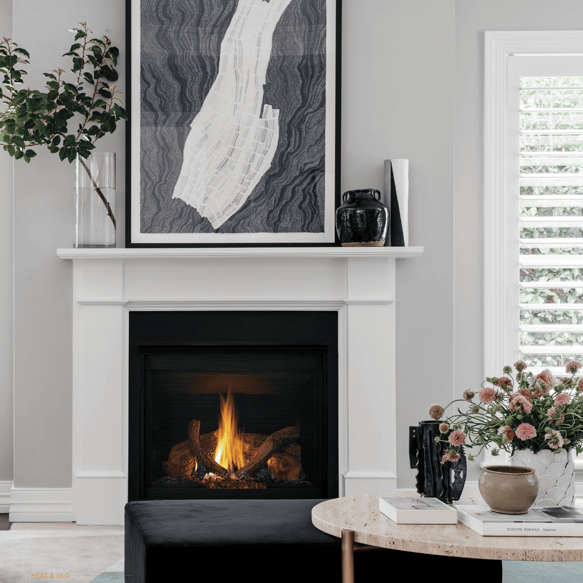 A cosy living room featuring a gas log fireplace with a painting displayed above it