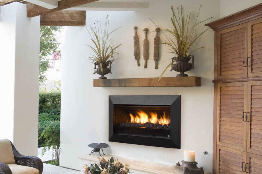A cosy living room featuring a Real Flame Exuro fireplace and wicker furniture, creating a warm and inviting atmosphere