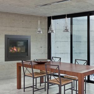 Heat & Glo 3X fireplace installed in a dining area with wood table and chandelier, a stylish choice in modern gas log fires for homes