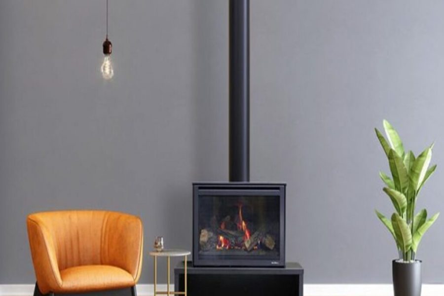 Heat & Glo i30-X freestanding fireplace with an orange chair and a potted plant beside it